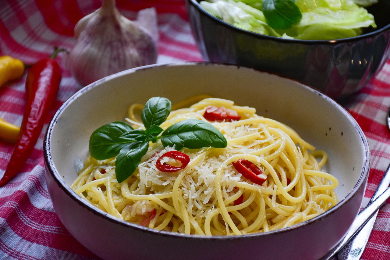 Pasta aglio olio e peperoncino gourmet con guarnizioni eleganti in un piatto raffinato.