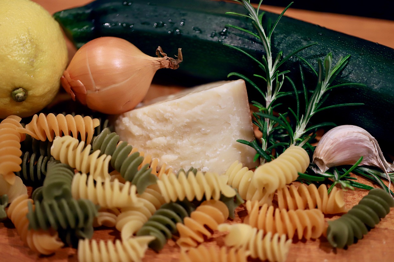 Piatto di pasta con zucchine e cipolle, decorato con prezzemolo fresco.