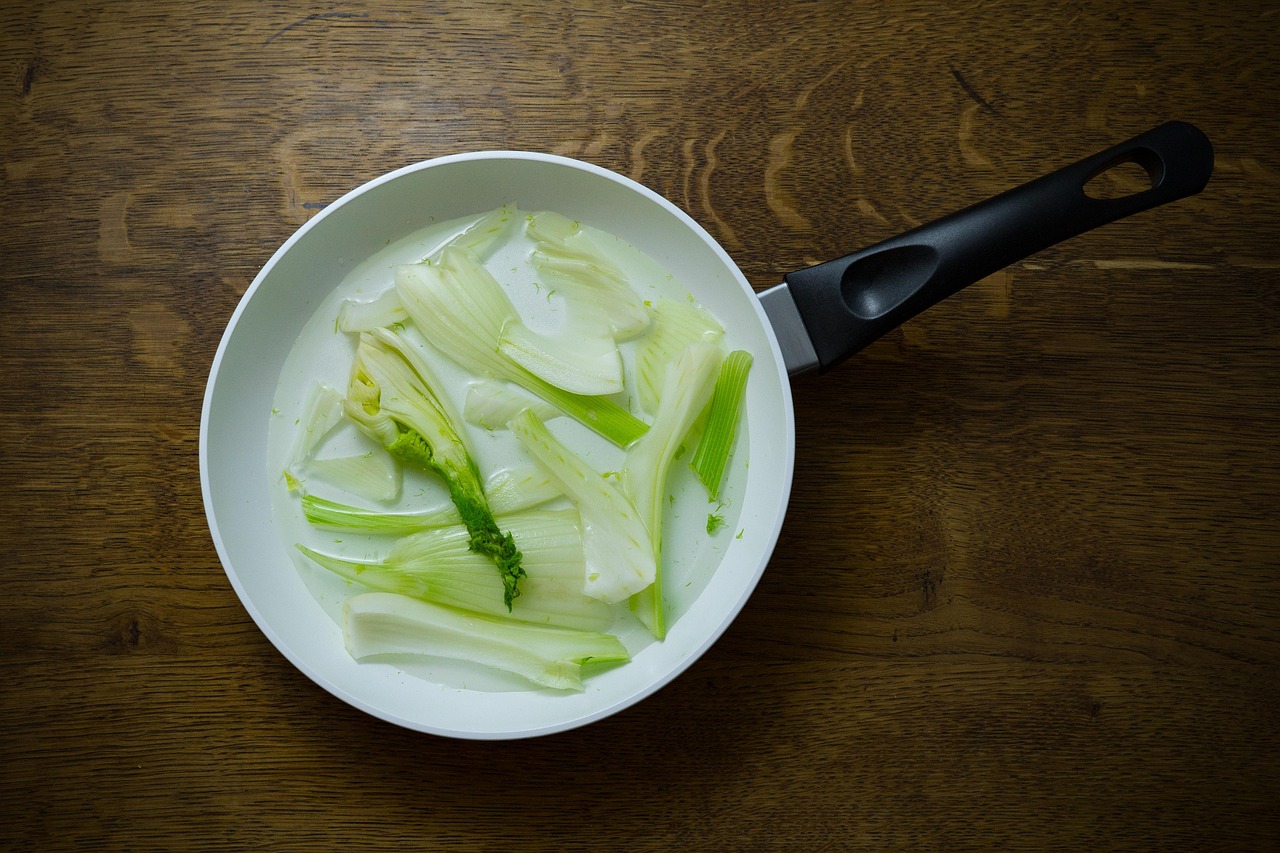 Finocchi in padella con aglio e olio, pronti da servire, con un profumo appetitoso e colori vivaci.