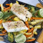 Filetti di merluzzo al forno dorati, serviti con contorni freschi e aromatici.