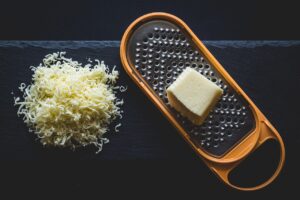 Formaggio grattugiato in un contenitore, pronto per essere congelato per preservarne la freschezza.