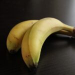 Banane con il picciolo avvolto in pellicola trasparente per una conservazione prolungata.