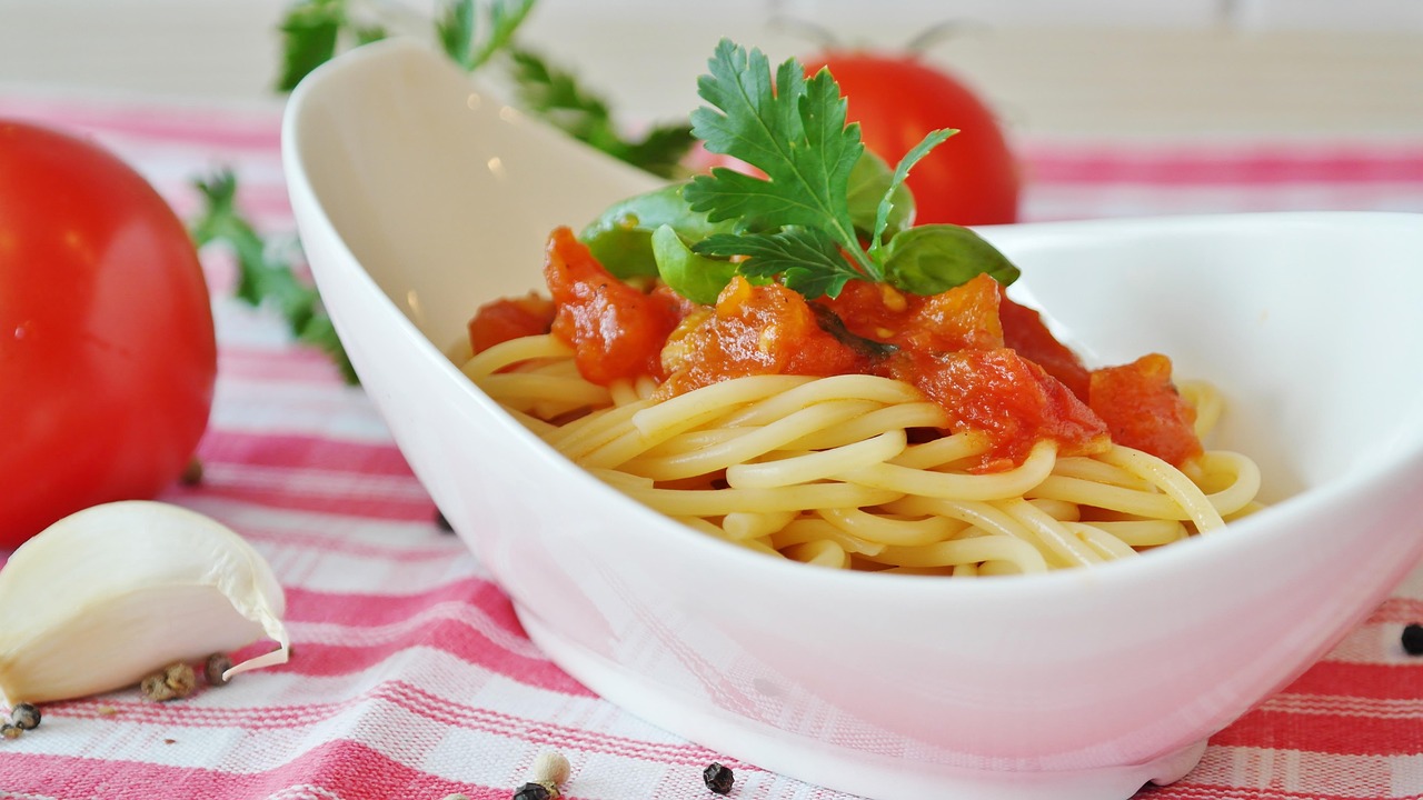 Pasta al pomodoro servita in un piatto, con focus su ingredienti freschi e sani.