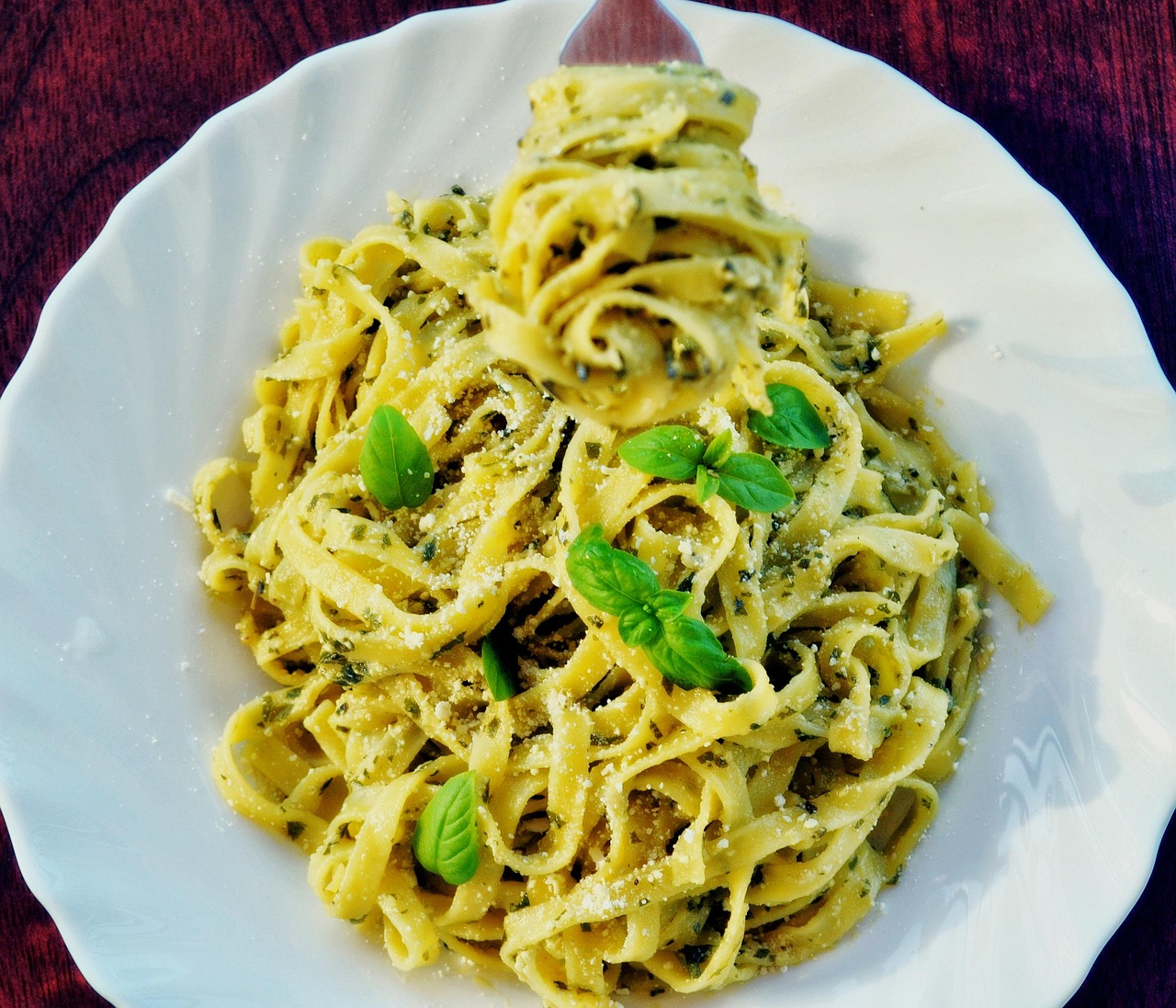 Pasta con pesto di zucchine, piatto leggero e colorato, decorato con foglie di basilico fresco.