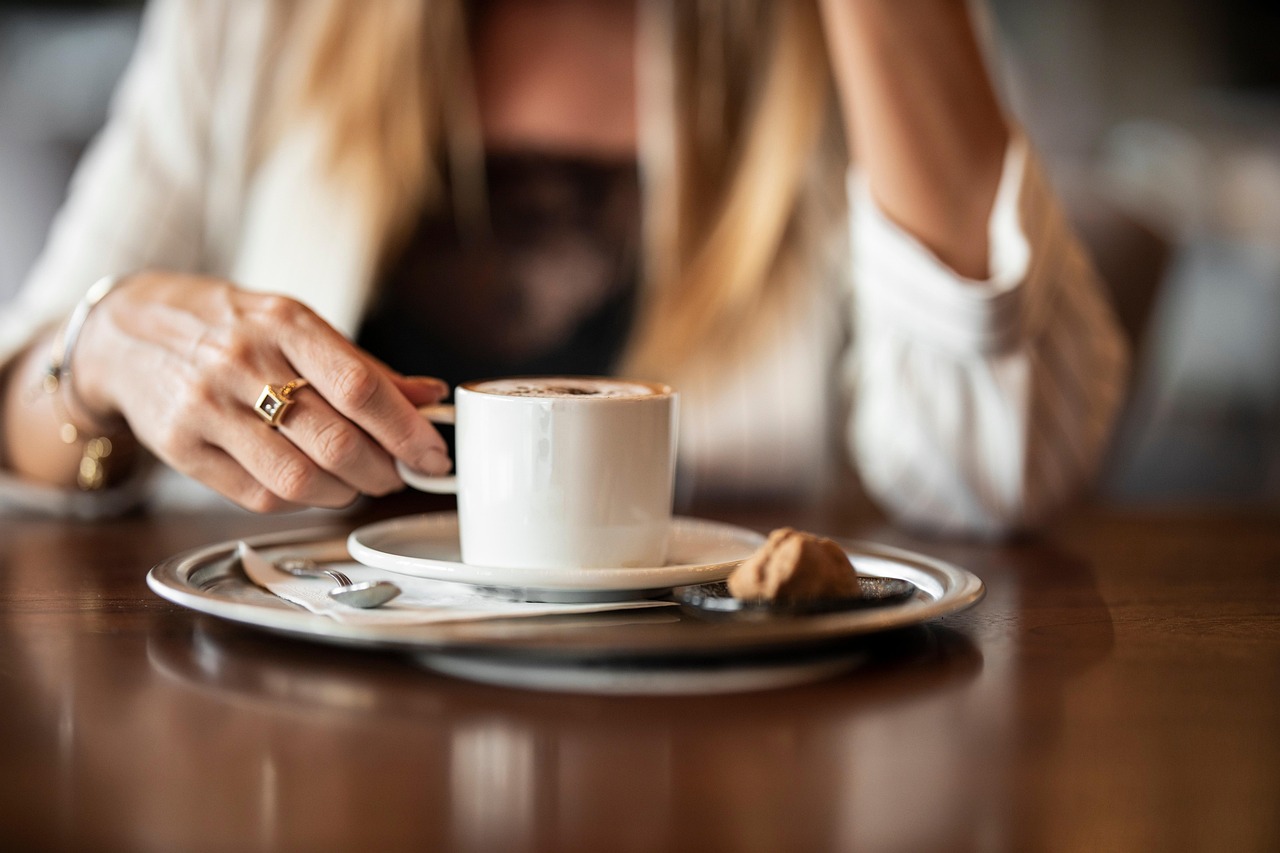 Tazza di caffè fumante su tavolo dopo un pranzo, simbolo di relax e digestione.