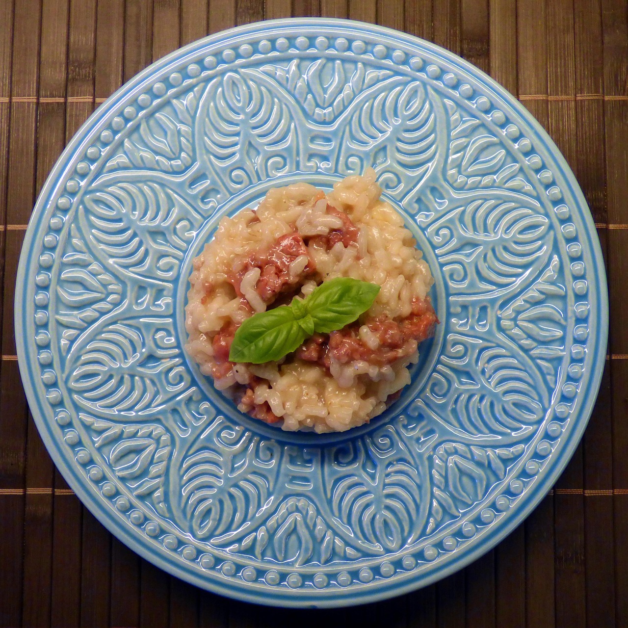 Risotto cremoso con salsiccia e radicchio, piatto gustoso e colorato servito in un elegante piatto bianco.