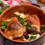 Pollo alla cacciatora con pomodori, olive e rosmarino in un piatto rustico.