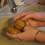 Patate non lavate su un tavolo da cucina, pronte per essere cucinate.