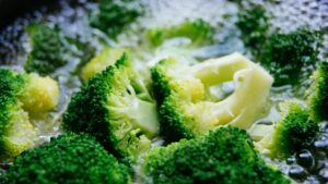 Fetta di pane imbevuta di aceto posizionata su un coperchio mentre si cuociono broccoli.